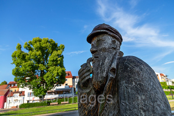 Deutschland, Waren (Mueritz) - volkstuemliche Holzskulptur eines Fischers mit Pfeife am Rand der Altstadt