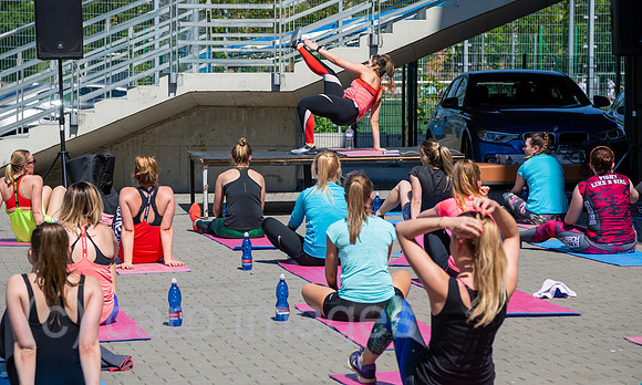 Polen, Warschau - Junge Frauen bei Fitnessuebungen unter Anleitung auf dem Parkplatz eines Fussballstadions