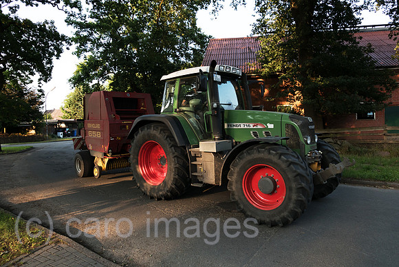 Deutschland, Heidenau - Landwirt unterwegs mit Traktor auf Dorfstrasse