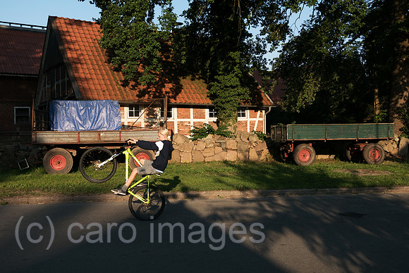 Deutschland, Heidenau - Junge auf dem Fahrrad auf Dorfstrasse