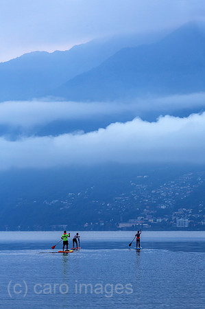 Schweiz, Ascona - Standup-Paddler auf dem Lago Maggiore in der Morgendaemmerung