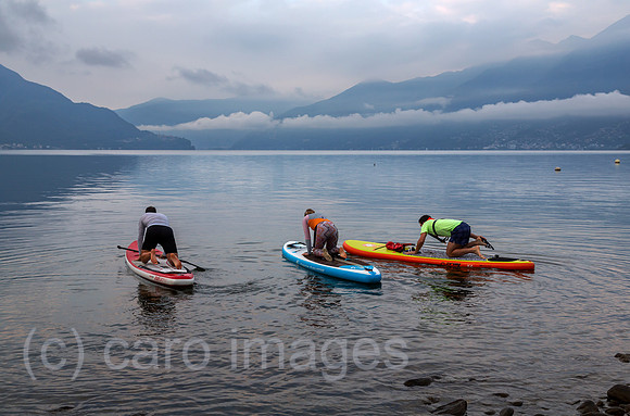 Schweiz, Ascona - Standup-Paddler auf dem Lago Maggiore in der Morgendaemmerung