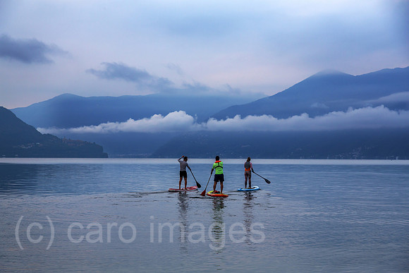 Schweiz, Ascona - Standup-Paddler auf dem Lago Maggiore in der Morgendaemmerung
