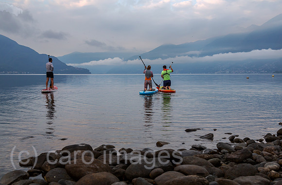 Schweiz, Ascona - Standup-Paddler am Lago Maggiore in der Morgendaemmerung