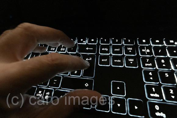 Deutschland, Bremen - Hand auf einer Computertastatur