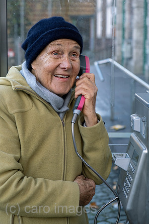 Deutschland, Bremen - Ruestige Rentnerin telefoniert an einer Telefonzelle der Deutschen Telekom