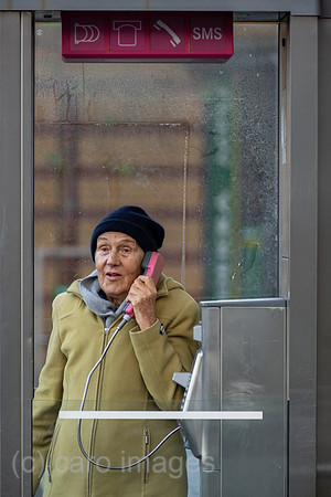 Deutschland, Bremen - Ruestige Rentnerin telefoniert an einer Telefonzelle der Deutschen Telekom