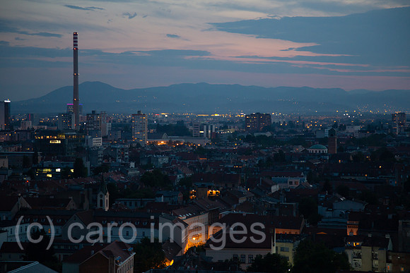 Kroatien, Zagreb - Uebersicht auf Teil des Stadtzentrums in der Abenddaemmerung, hinten Berge