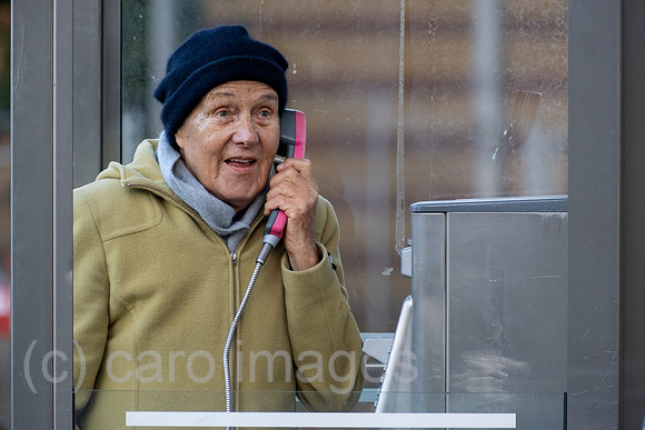 Deutschland, Bremen - Ruestige Rentnerin telefoniert an einer Telefonzelle der Deutschen Telekom