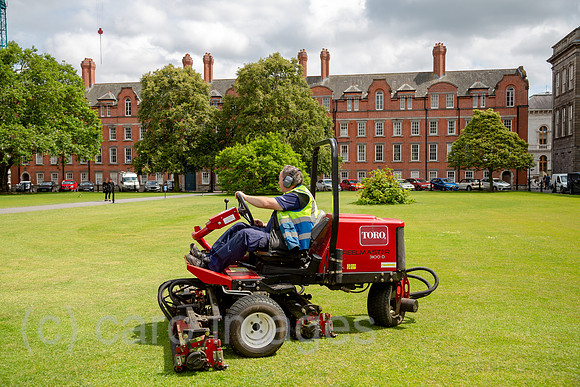 Republik Irland, Dublin - Trinity College 1592, Gaertner maeht den Rasen mit Rasentraktor auf dem Campus