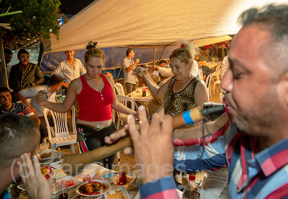 Tuerkei, Bogazkoey Sarıyahsi - Engagierte Taenzerin bei traditioneller Hochzeit auf dem Dorf in Anatolien, Maenner und Frauen sitzen getrennt