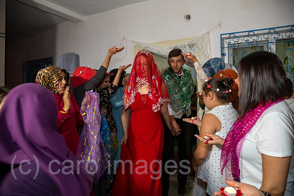 Tuerkei, Bogazkoey Sarıyahsi - Hochzeit auf dem Dorf in Anatolien: Das polnisch-tuerkische Brautpaar tritt in traditioneller Kleidung aus dem Haus, wo es von Familie und Gaesten mit Kerzen begruesst