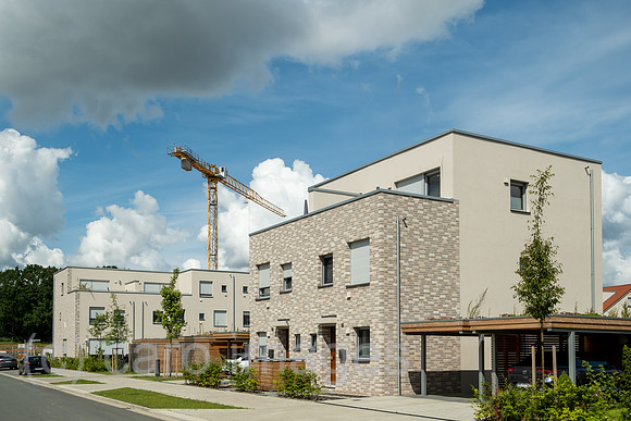 Deutschland, Bremen - Baustelle fuer eine Wohnsiedlung, links bereits fertiggstellte Haeuser