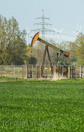 Deutschland, Barenburg - Erdoelproduktionsbohrung von Exxon Mobile mit einer Pferdekopfpumpe, hinten Windraeder und Strommast
