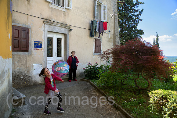Kroatien, Labin - das malerische, altertuemliche Bergstaedtchen Labin: Grossmutter spielt Ball mit ihrer Enklin