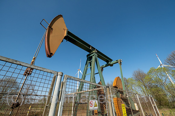 Deutschland, Barenburg - Erdoelproduktionsbohrung von Exxon Mobile mit einer Pferdekopfpumpe, hinten Windraeder