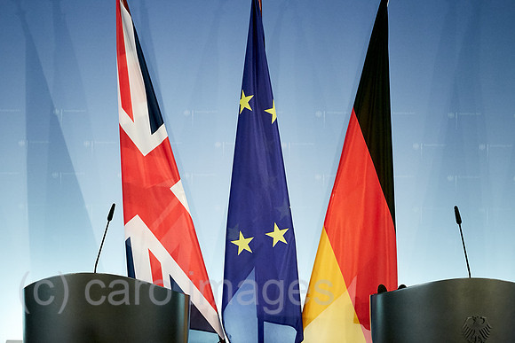 Berlin, Deutschland - Die Fahnen von Grossbritannien, der Europaeischen Union und Deutschlands haengen an Standarten hinter zwei Stehpulten vor einer Logowand in einem Presseraum des Aussenministeriu
