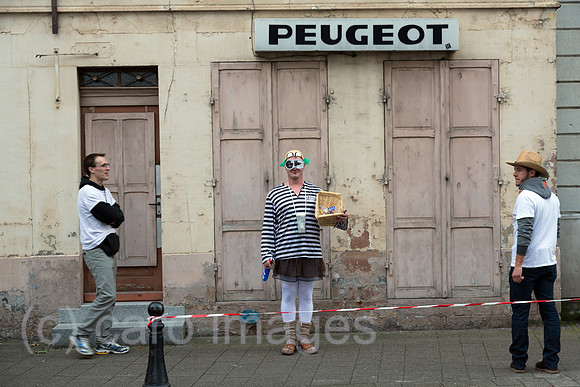 Frankreich - Strassenszene mit verkleidetem Mann und Peugeot-Schriftzug