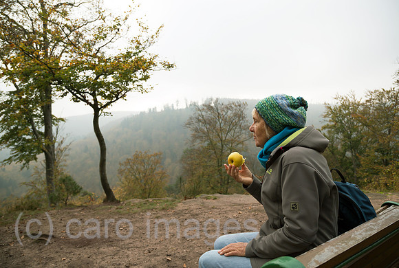 Frankreich, Wanderin bei einer Pause auf einer Bank im Regionaler Naturpark Nordvogesen, Elsass