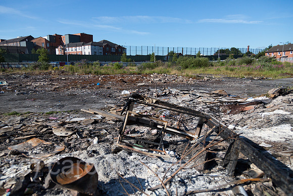 Grossbritannien, Nordirland, Belfast - Protestantischer Teil von West Belfast - verwahrloster, verbrannter Platz nach dem bonfire vom Orangemens Day, hinten der Peace Wall