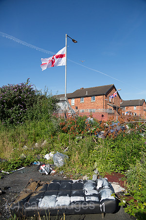 Grossbritannien, Nordirland, Belfast - Protestantischer Teil von West Belfast - verwahrloster, verbrannter Platz nach dem bonfire vom Orangemens Day mit Ulster Flagge