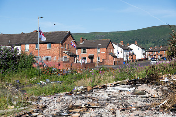 Grossbritannien, Nordirland, Belfast - Protestantischer Teil von West Belfast - verwahrloster, verbrannter Platz nach dem bonfire vom Orangemens Day mit Ulster Flagge