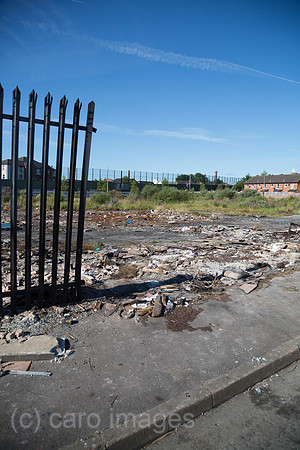Grossbritannien, Nordirland, Belfast - Protestantischer Teil von West Belfast - verwahrloster, verbrannter Platz nach dem bonfire vom Orangemens Day, hinten der Peace Wall
