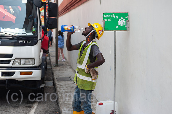 Singapur, Republik Singapur, Arbeiter trinkt Wasser aus einer Flasche in Chinatown