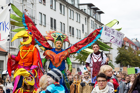 Deutschland, Bremen - fridays for future - Demonstration, erwachsene als Paradiesvoegel verkleidete Teilnehmer auf Stelzen