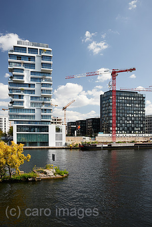 Berlin, Deutschland - Blick ueber die Spree auf neu erbaute Wohn- und Buerohaeuser am Flussufer in Berlin-Friedrichshain.