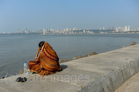 Mumbai, Indien, Frau sitzt an der Uferpromenade entlang der Marine Drive