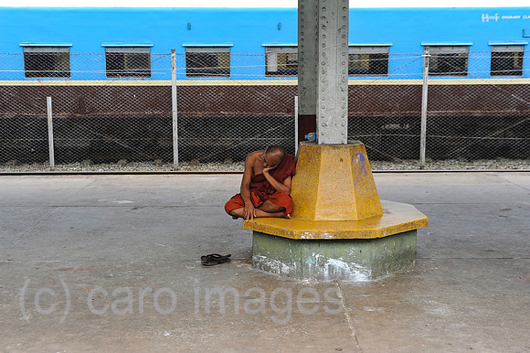 Yangon, Myanmar, Buddhistischer Moench wartet am Bahnsteig auf den Zug