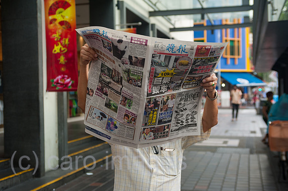 Republik Singapur, Mann liest Zeitung in Chinatown