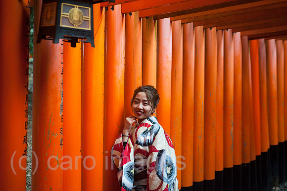 Kyoto, Japan, Eine Japanerin posiert in einem Torii-Weg zum Fushimi Inari-Taisha