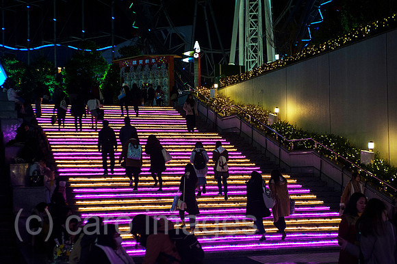 Tokio, Japan, Fussgaenger gehen eine beleuchtete Treppe hoch