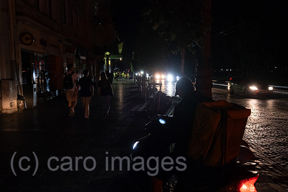 Ukraine, Lviv - Pedestrians on Prospekt Svobody in the dark. Due to Russia's attacks on the energy infrastructure, there are frequent power cuts