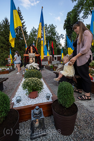 Ukraine, Lwiw - Witwe mit Tochter trauert am Grab ihres Manns auf dem Marsfeld, Ehrenfriedhof der gefallenen Lwiwer Soldaten im Ukrainekrieg