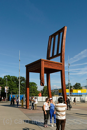 Schweiz, Genf - Das Holzdenkmal BROKEN CHAIR symbolisiert den Kampf gegen Antipersonenminen, Place des Nations beim Buero der Vereinten Nationen in Genf, ist auch Touristenattraktion