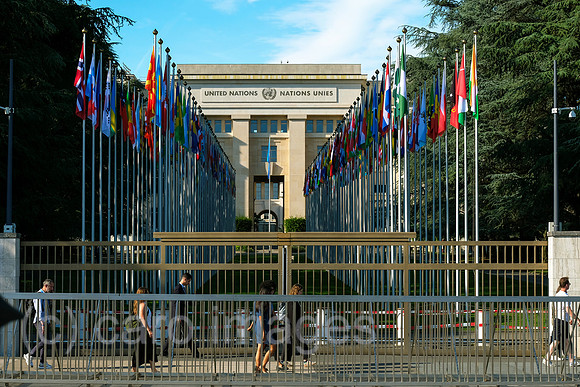 Schweiz, Genf - Buero der Vereinten Nationen in Genf, zweiter Hauptsitz der UN im Palais des Nations, Hauptgebaeude mit Flaggen der Nationen am Place des Nations