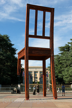 Schweiz, Genf - Das Holzdenkmal BROKEN CHAIR symbolisiert den Kampf gegen Antipersonenminen, Place des Nations beim Buero der Vereinten Nationen in Genf, ist auch Touristenattraktion