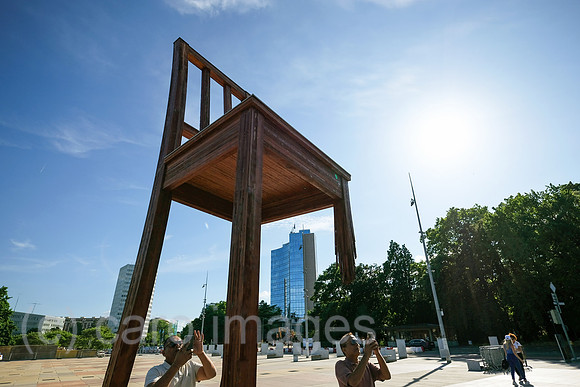 Schweiz, Genf - Das Holzdenkmal BROKEN CHAIR symbolisiert den Kampf gegen Antipersonenminen, Place des Nations beim Buero der Vereinten Nationen in Genf, ist auch Touristenattraktion
