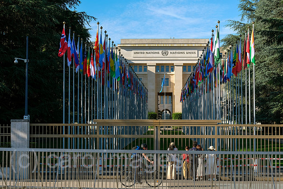 Schweiz, Genf - Buero der Vereinten Nationen in Genf, zweiter Hauptsitz der UN im Palais des Nations, Hauptgebaeude mit Flaggen der Nationen am Place des Nations
