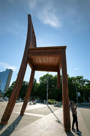 Schweiz, Genf - Das Holzdenkmal BROKEN CHAIR symbolisiert den Kampf gegen Antipersonenminen, Place des Nations beim Buero der Vereinten Nationen in Genf, ist auch Touristenattraktion