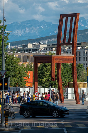 Schweiz, Genf - Das Holzdenkmal BROKEN CHAIR symbolisiert den Kampf gegen Antipersonenminen, Place des Nations beim Buero der Vereinten Nationen in Genf, ist auch Touristenattraktion