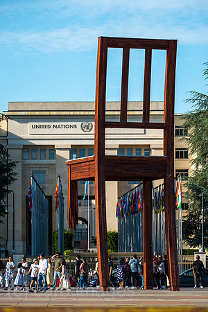 Schweiz, Genf - Das Holzdenkmal BROKEN CHAIR symbolisiert den Kampf gegen Antipersonenminen, Place des Nations beim Buero der Vereinten Nationen in Genf, ist auch Touristenattraktion