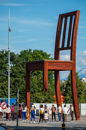 Schweiz, Genf - Das Holzdenkmal BROKEN CHAIR symbolisiert den Kampf gegen Antipersonenminen, Place des Nations beim Buero der Vereinten Nationen in Genf, ist auch Touristenattraktion