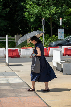 Schweiz, Genf - Junge Frau im internationalen Viertel nutzt eine Regenschirm zum Sonnenschutz