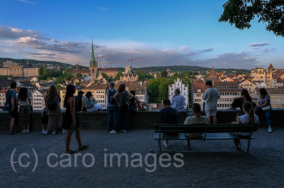 Schweiz, Zuerich - Touristen am Aussichtspunkt Lindenhof am rechten Flussufer des Flusses Limmat mit Blick auf die andere Haelfte der Altstadt