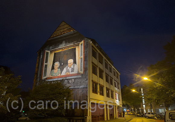 Deutschland, Bremen - Das bekannte Wandbild Oma und Opa am Rembertikreisel bei Nacht, eigentlicher Name: Blick aus dem Fenster