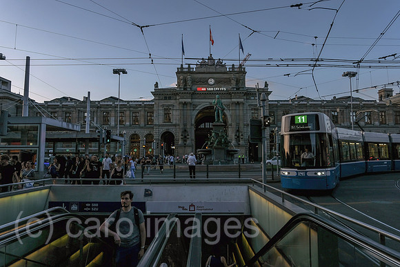 Schweiz, Zuerich - Zuerich Hauptbahnhof, Haupteingang zum Bahnhofplatz / Bahnhofstrasse mit Zugang zum Untergrund und Alfred Escher-Denkmal, rechts Tram